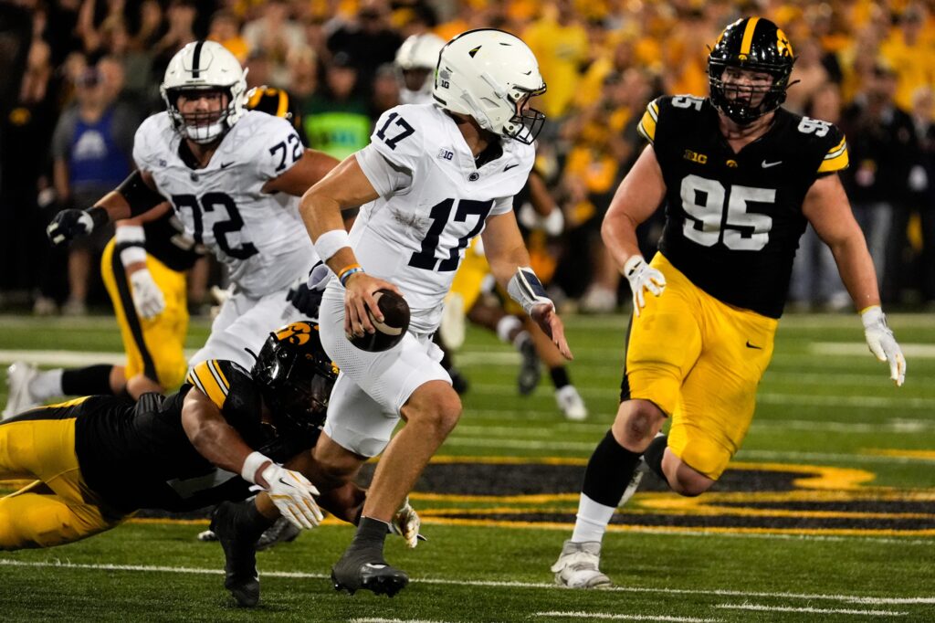 Penn State Nittany Lions quarterback Ethan Grunkemeyer (17) scrambles away from Iowa Hawkeyes defensive back Xavier Nwankpa (1) and Iowa Hawkeyes defensive lineman Aaron Graves (95) during a college football game Oct. 18, 2025 at Kinnick Stadium in Iowa City, Iowa.