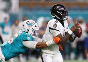 Oct 30, 2025; Miami Gardens, Florida, USA; Baltimore Ravens quarterback Lamar Jackson (8) is tackled by Miami Dolphins linebacker Jaelan Phillips (15) during the first quarter at Hard Rock Stadium. Mandatory Credit: