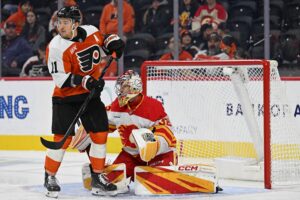 Nov 2, 2025; Philadelphia, Pennsylvania, USA; Philadelphia Flyers right wing Travis Konecny (11) battles for position against Calgary Flames goaltender Dustin Wolf (32) during the second period at Xfinity Mobile Arena.