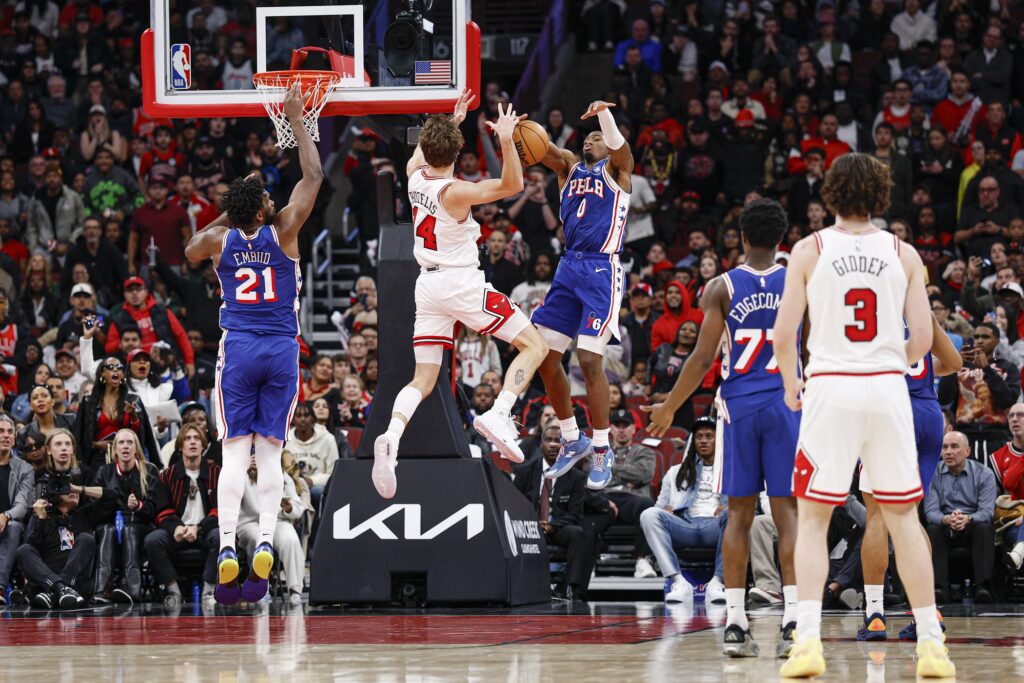 Nov 4, 2025; Chicago, Illinois, USA; Philadelphia 76ers guard Tyrese Maxey (0) defends against Chicago Bulls forward Matas Buzelis (14) during the second half at United Center.