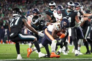 Nov 28, 2025; Philadelphia, Pennsylvania, USA; Chicago Bears running back Kyle Monangai (25) carries the ball for a touchdown defended by Philadelphia Eagles cornerback Quinyon Mitchell (27) and linebacker Nakobe Dean (17) during the fourth quarter of the game at Lincoln Financial Field.