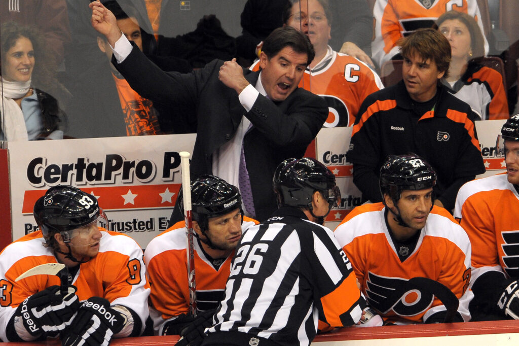 October 24, 2011; Philadelphia, PA USA; Philadelphia Flyers coach Peter Laviolette argues with referee Rob Martell (26) during game against the Toronto Maple Leafs at the Wells Fargo Center in Philadelphia. The Flyers defeated the Maple Leafs 4-2.