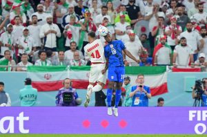 Nov 29, 2022; Doha, Qatar; Iran forward Saman Ghoddos (14) battles for a header against United States of America defender Shaq Moore (18) during the second half of a group stage match during the 2022 World Cup at Al Thumama Stadium.