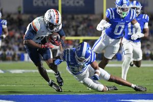 Nov 15, 2025; Durham, North Carolina, USA; Virginia Cavaliers wide receiver Trell Harris (11) takes a hit from Duke Blue Devils saftey Ma'khi Jones (26) during the third quarter at Wallace Wade Stadium.