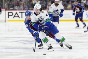 Dec 2, 2025; Denver, Colorado, USA; Colorado Avalanche center Martin Necas (88) defends on Vancouver Canucks defenseman Quinn Hughes (43) during the second period at Ball Arena.