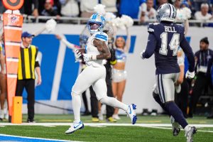 Detroit Lions running back Jahmyr Gibbs (0) runs for a touchdown against Dallas Cowboys safety Markquese Bell (14) during the second half at Ford Field in Detroit on Thursday, Dec. 4, 2025.