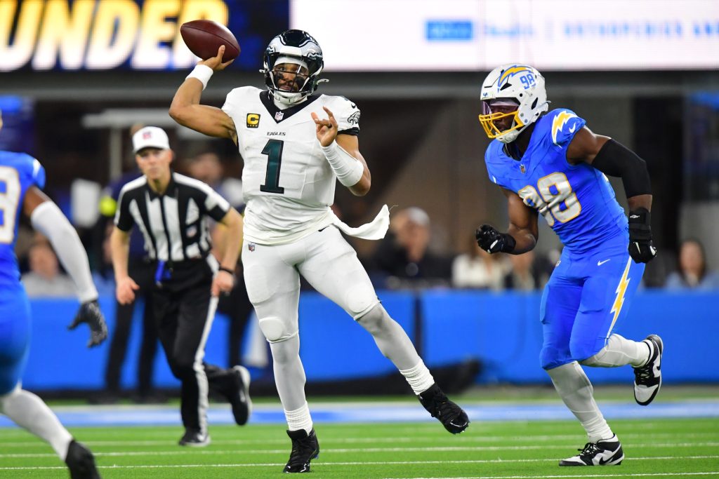 Dec 8, 2025; Inglewood, California, USA; Philadelphia Eagles quarterback Jalen Hurts (1) passes against Los Angeles Chargers linebacker Odafe Oweh (98) in the second half at SoFi Stadium.