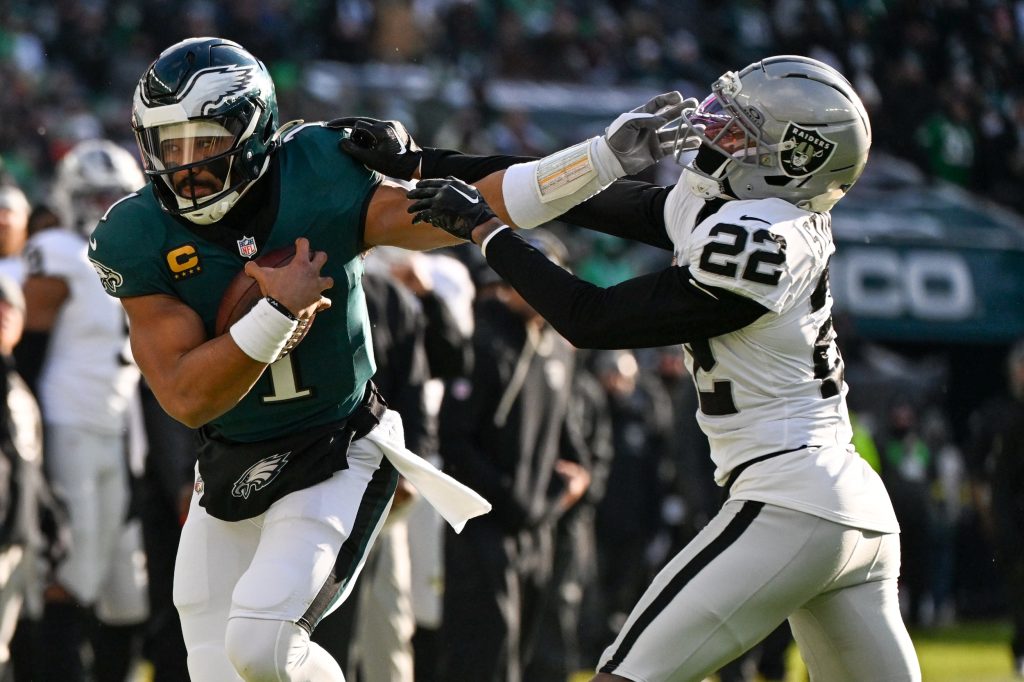 Dec 14, 2025; Philadelphia, Pennsylvania, USA; Philadelphia Eagles quarterback Jalen Hurts (1) blocks against Las Vegas Raiders cornerback Eric Stokes (22) during the second quarter at Lincoln Financial Field.