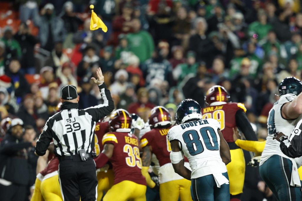 Dec 20, 2025; Landover, Maryland, USA; Back judge Rich Martinez (39) throws a flag into the air during a fight between Philadelphia Eagles and Washington Commanders players in the fourth quarter at Northwest Stadium.