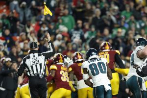 Dec 20, 2025; Landover, Maryland, USA; Back judge Rich Martinez (39) throws a flag into the air during a fight between Philadelphia Eagles and Washington Commanders players in the fourth quarter at Northwest Stadium.