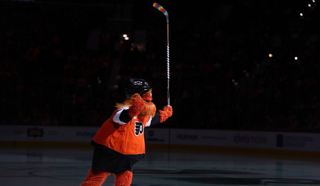 Jan 12, 2026; Philadelphia, Pennsylvania, USA; Philadelphia Flyers mascot Gritty entertains fans with rainbow stick tape for Pride Night before the game against the Tampa Bay Lightning at Xfinity Mobile Arena.