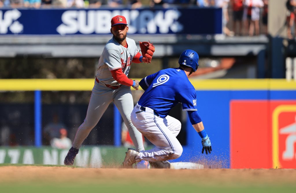 Feb 21, 2026; Dunedin, Florida, USA; Philadelphia Phillies infielder Edmundo Sosa (33) forces out Toronto Blue Jays outfielder RJ Schreck (9) and throws the ball to first base for a double play during the sixth inning at TD Ballpark.
