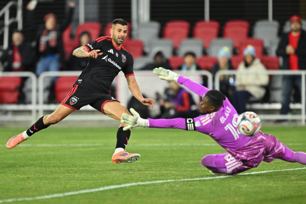 Feb 21, 2026; Washington, District of Columbia, USA; DC United forward Tai Baribo (9) scores on Philadelphia Union goalkeeper Andre Blake (18) in the first half at Audi Field.
