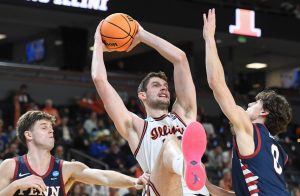 Penn Quakers guard Michael Zanoni (7) and Penn Quakers guard AJ Levine (0) defend Illinois Fighting Illini center Tomislav Ivisic (13) Thursday, March 19, 2026, during the NCAA Men’s Basketball Tournament first round game at Bon Secours Wellness Arena in Greenville, South Carolina. Illinois Fighting Illini won 105-70.