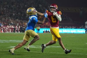 Nov 29, 2025; Los Angeles, California, USA; Southern California Trojans wide receiver Makai Lemon (6) carries the ball against UCLA Bruins defensive back Andre Jordan Jr. (2) in the second half at United Airlines Field at Los Angeles Memorial Coliseum.