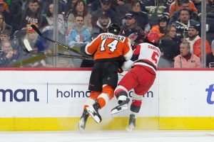 Dec 13, 2025; Philadelphia, Pennsylvania, USA; Philadelphia Flyers center Sean Couturier (14) hits Carolina Hurricanes defenseman Jalen Chatfield (5) in the second period at Xfinity Mobile Arena.