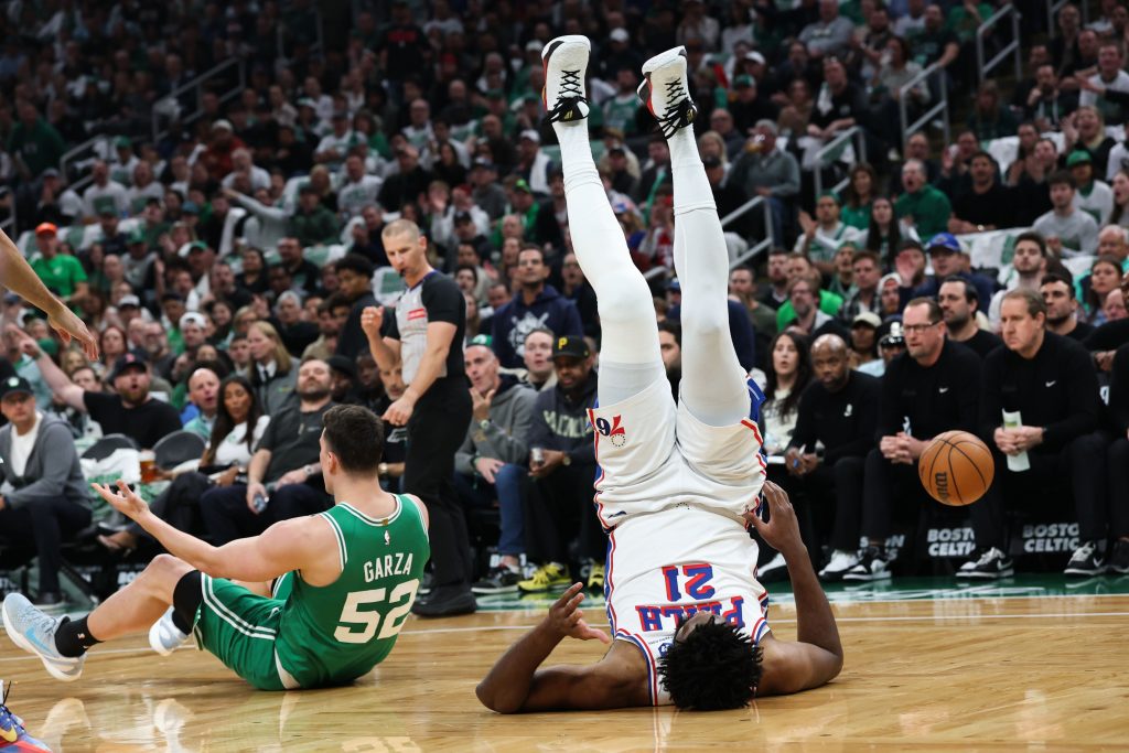 May 2, 2026; Boston, Massachusetts, USA; Philadelphia 76ers center Joel Embiid (21) goes tumbling after being fouled by Boston Celtics center Luka Garza (52) during the first quarter of game seven of the first round of the 2026 NBA Playoffs at TD Garden.