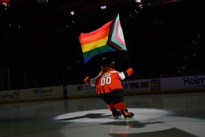 Jan 10, 2024; Philadelphia, Pennsylvania, USA; Philadelphia Flyers mascot Gritty carries a flag in support of LGBTQ+ community during annual Pride Game against the Montreal Canadiens at Wells Fargo Center.