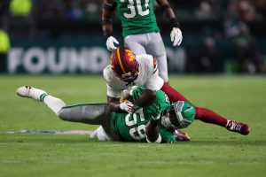 Jan 4, 2026; Philadelphia, Pennsylvania, USA; Philadelphia Eagles linebacker Jalyx Hunt (58) intercepts a pass intended for Washington Commanders wide receiver Deebo Samuel (1) during the second quarter at Lincoln Financial Field.