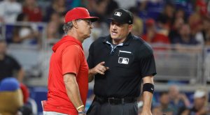 Jul 27, 2026; Miami, Florida, USA; Philadelphia Phillies interim manager Don Mattingly (8) speaks with home plate umpire Dan Bellino against the Miami Marlins during the sixth inning at loanDepot Park.