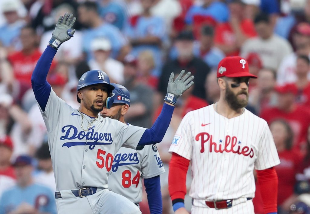 Oct 6, 2025; Philadelphia, Pennsylvania, USA; Los Angeles Dodgers shortstop Mookie Betts (50) celebrates a single as Philadelphia Phillies first baseman Bryce Harper (3) looks on in the first inning during game two of the NLDS round for the 2025 MLB playoffs at Citizens Bank Park.
