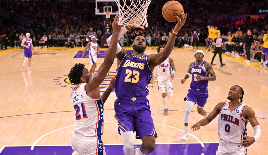 Feb 5, 2026; Los Angeles, California, USA; Los Angeles Lakers forward LeBron James (23) drives past Philadelphia 76ers center Joel Embiid (21) in the second half at Crypto.com Arena.