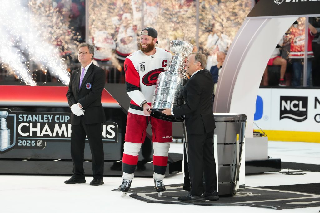 Jun 14, 2026; Las Vegas, Nevada, USA; Carolina Hurricanes center Jordan Staal (11) picks up the the Stanley Cup from Commissioner of the NHL Gary Bettman after defeating the Vegas Golden Knights in game six of the 2026 Stanley Cup Final at T-Mobile Arena.