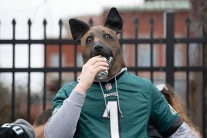Luke Godzieba of Delaware County chugs a can of beer with a dog, or what he calls an "underdog," mask at a parking lot near Lincoln Financial Field in Philadelphia before Eagles' NFL conference championship game against 49ers on Sunday, Jan. 29, 2023. Eaglestailgating17