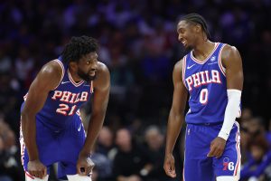 Oct 25, 2025; Philadelphia, Pennsylvania, USA; Philadelphia 76ers guard Tyrese Maxey (0) and center Joel Embiid (21) talks during a break in action in the second quarter against the Charlotte Hornets at Xfinity Mobile Arena.