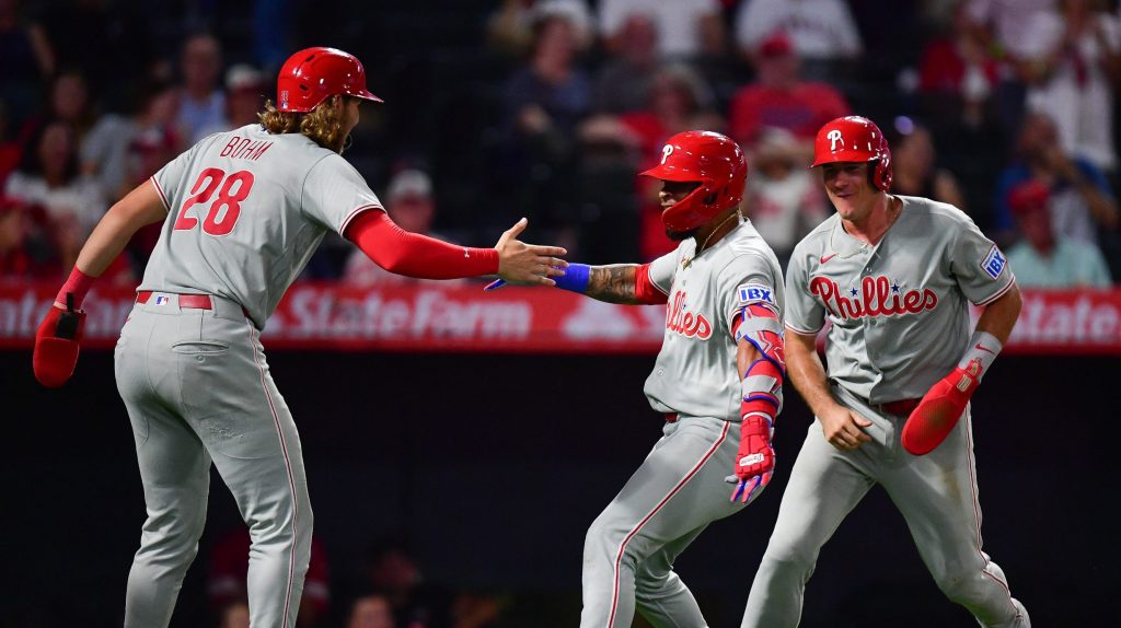 Aug 28, 2026; Anaheim, California, USA; Philadelphia Phillies left fielder Edmundo Sosa (33) is greeted by catcher J.T. Realmuto (10) and third baseman Alec Bohm (28) after hitting a grand slam home run against the Los Angeles Angels during the ninth inning at Angel Stadium.