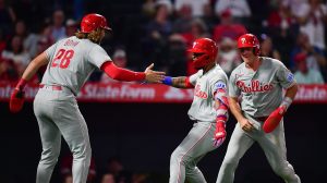 Aug 28, 2026; Anaheim, California, USA; Philadelphia Phillies left fielder Edmundo Sosa (33) is greeted by catcher J.T. Realmuto (10) and third baseman Alec Bohm (28) after hitting a grand slam home run against the Los Angeles Angels during the ninth inning at Angel Stadium.