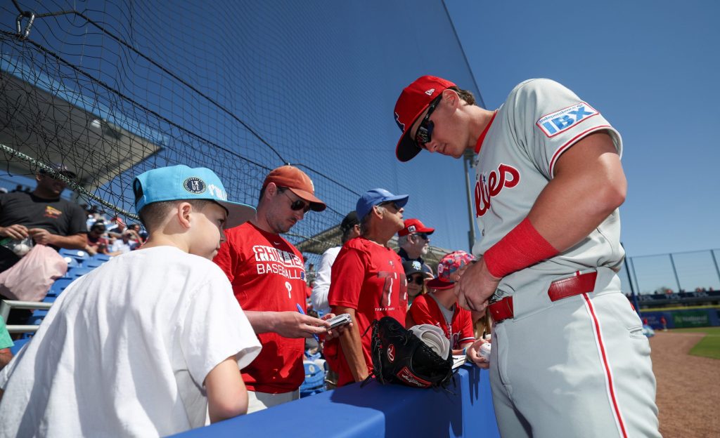 Mar 2, 2025; Dunedin, Florida, USA; Philadelphia Phillies infielder Aidan Miller (81) signs autographs for fans before a game against the Toronto Blue Jays during spring training at TD Ballpark.