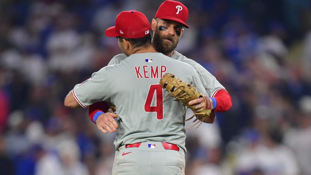 Sep 15, 2025; Los Angeles, California, USA; Philadelphia Phillies third baseman Otto Kemp (4) and first baseman Bryce Harper (3) celebrate the victory against the Los Angeles Dodgers and clinching the National League East division title at Dodger Stadium.