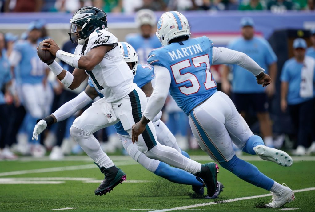 Tennessee Titans defensive end Jermaine Johnson II (11) and defensive end Jacob Martin (57) pressure Philadelphia Eagles quarterback Jalen Hurts (1) during the third quarter Sept. 20 at Nissan Stadium in Nashville, Tenn.