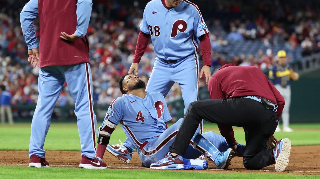 Sep 24, 2026; Philadelphia, Pennsylvania, USA; Philadelphia Phillies second baseman Luis Arraez (4) is checked on by trainer Christian Bermudez and first base coach Paco Figueroa (38) after being injured on a play against the Milwaukee Brewers during the sixth inning at Citizens Bank Park.