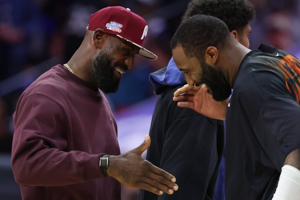 Oct 5, 2026; Philadelphia, Pennsylvania, USA; Philadelphia 76ers forward LeBron James (L) greets New York Knicks center Andre Drummond (R) during a timeout in the first quarter at Xfinity Mobile Arena.