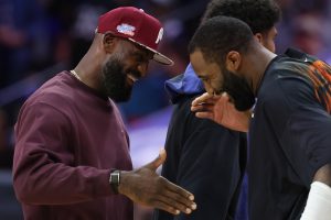 Oct 5, 2026; Philadelphia, Pennsylvania, USA; Philadelphia 76ers forward LeBron James (L) greets New York Knicks center Andre Drummond (R) during a timeout in the first quarter at Xfinity Mobile Arena.