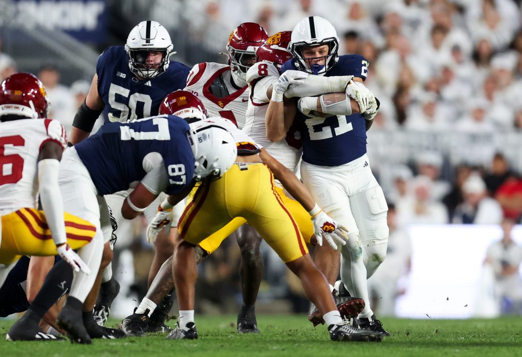 Oct 10, 2026; University Park, Pennsylvania, USA; Penn State Nittany Lions running back Carson Hansen (21) runs with the ball before being tackle by Southern California Trojans linebacker Desman Stephens II (8) during the first quarter of the game at West Shore Home Field at Beaver Stadium.