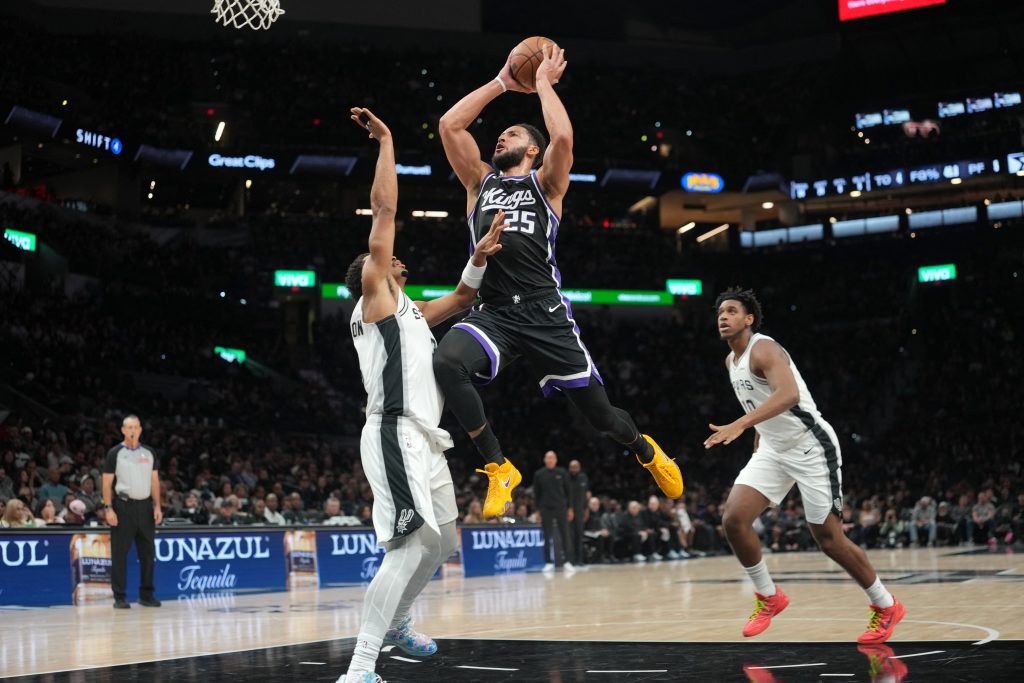 Oct 16, 2026; San Antonio, Texas, USA; Sacramento Kings guard Ben Simmons (25) drives to the basket between forward Keldon Johnson (3) and center Tarris Reed, Jr. (10) during the second half against the San Antonio Spurs at Frost Bank Center.
