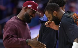 Oct 5, 2026; Philadelphia, Pennsylvania, USA; Philadelphia 76ers forward LeBron James (L) greets New York Knicks center Andre Drummond (R) during a timeout in the first quarter at Xfinity Mobile Arena.