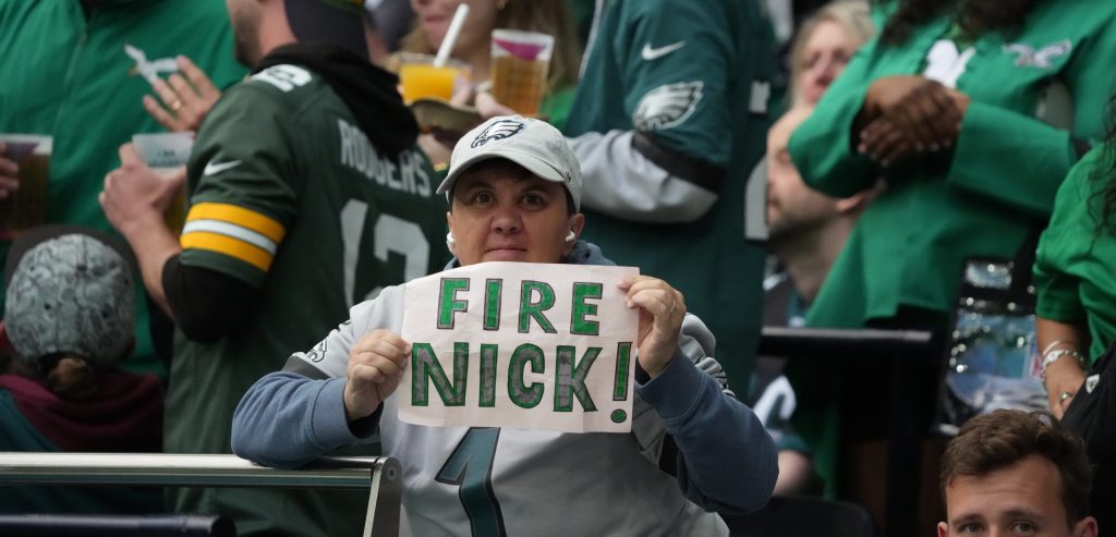 Oct 11, 2026; Tottenham, ENG; Oct 11, 2026; Tottenham, ENG; A fan holds a sign imploring the Philadelphia Eagles to fire head coach Nick Sirianni during the second half of the game against the Jacksonville Jaguars at Tottenham Hotspur Stadium. Mandatory Credit: Kirby Lee-Imagn Images.
